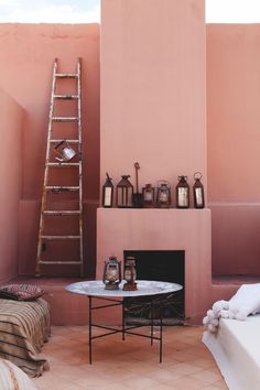 a living room with pink walls and a ladder leaning up against the wall next to a fireplace