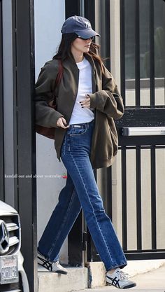 a woman is walking down the street with her hand in her pocket