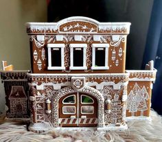 there is a gingerbread house with white decorations on the front and side windows,