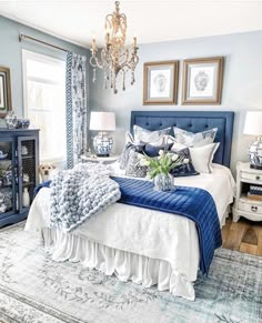 a dog laying on top of a bed in a room with blue and white decor