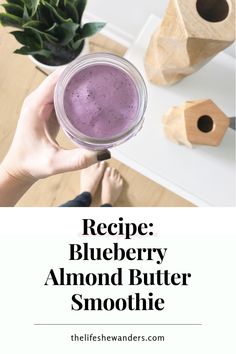 a person holding up a purple smoothie in their hand with the words recipe blueberry almond butter smoothie