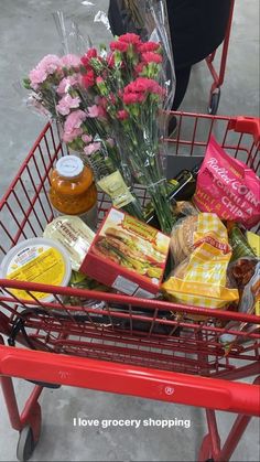 a shopping cart filled with food and flowers