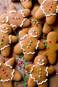 several gingerbreads with white icing and sprinkles on a table