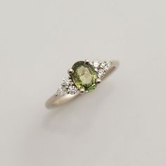 an oval shaped green and white diamond ring