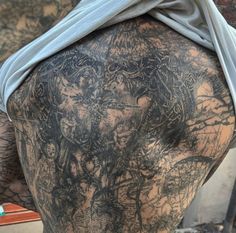 the back of a man with tattoos on his body