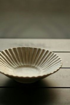 a white bowl sitting on top of a wooden table