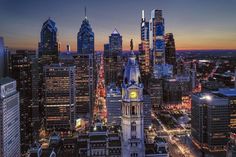 an aerial view of a city at night with skyscrapers lit up in the background