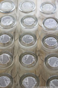 there are many jars with labels on them sitting on the wooden table and ready to be filled