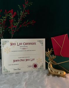 a certificate sitting on top of a table next to a vase with flowers in it