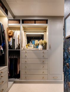 a walk in closet filled with lots of drawers and clothes on top of wooden shelves