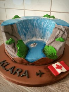 a cake that is shaped to look like a mountain with a lake and canadian flag on it