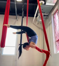 a woman is doing aerial acrobatics on a pole