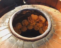 some food is sitting in the middle of a fire pit with bricks and cement around it