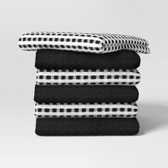 four black and white towels stacked on top of each other