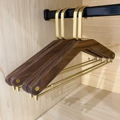 a wooden shelf with two metal bars on it and a brown umbrella hanging from the wall