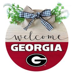 a wooden sign that says welcome to the university of georgia with a bow on it