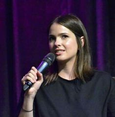 a woman standing in front of a microphone