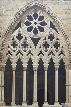 an ornate window in the side of a stone building with columns and arches on either side