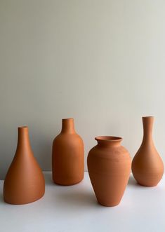 three brown vases sitting next to each other on a table