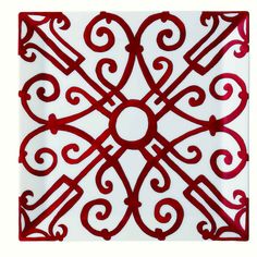 a red and white square tile with an intricate design on the bottom, in front of a white background