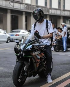 a man riding on the back of a motorcycle down a street