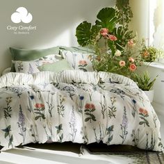 an image of a bed with flowers on the comforter and pillow cases in front of a window