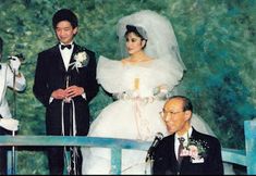 two men and a woman in formal wear standing next to each other at a wedding