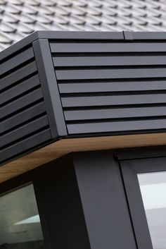 a close up view of the side of a building with black shutters and wood slats