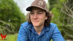 a young man wearing a brown hat and blue shirt