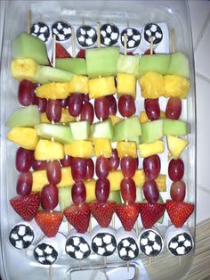 fruit skewers are arranged in the shape of soccer balls and checkered strawberries