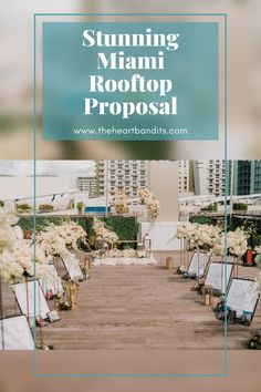 an outdoor ceremony setup with white flowers and greenery on the aisle, surrounded by tall buildings