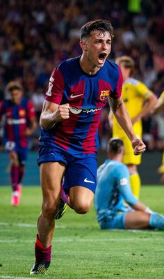 a soccer player running on the field with his mouth open and one foot in the air