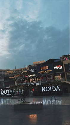 an image of a building that is lit up with lights and people walking around it