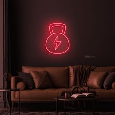 a living room with a couch, coffee table and neon sign on the wall above it