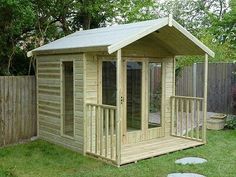 a small wooden shed sitting in the grass