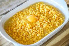 corn in a white dish with an egg on top