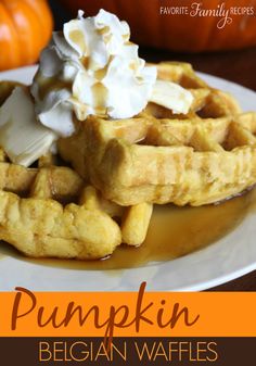 a waffle topped with whipped cream and syrup on a plate next to pumpkins