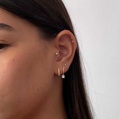 a close up of a person wearing earring with an ear ring on their left side