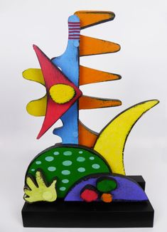 a colorful sculpture is sitting on a black stand