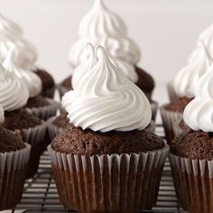 chocolate cupcakes with white frosting on a cooling rack