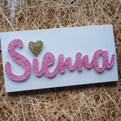 a white card with pink and gold sequins that says stena on it