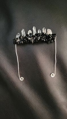 a pair of black and white hair clips with crystal beads on it's ends