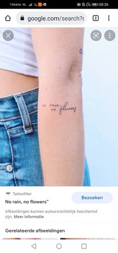 the back of a woman's left arm with a small tattoo on it