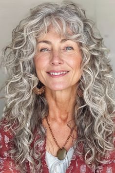 Voluminous, romantic, and enticing, this layered curls with side-swept fringe hairstyle does not disappoint. While it looks complex and challenging to maintain, it couldn’t be easier.  Click here to check out more best long hairstyles for women over 60. Loose Spiral Perm Long Hair, Long Curly Hair With Fringe, Permed Hairstyles Long, Curly Long Hair With Bangs, Over 60 Long Hairstyles, Curly Grey Hair Natural Curls, Long Hippie Hair, Long Curly Gray Hair, Big Fluffy Hair