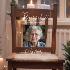 an elderly woman sitting in a chair with a memorial plaque on it's back