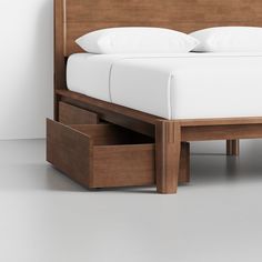 a bed with two drawers underneath it and a white pillow on top of the bed