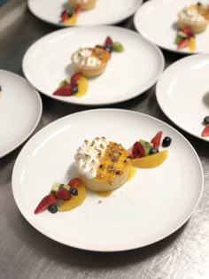 several white plates topped with desserts on top of a table