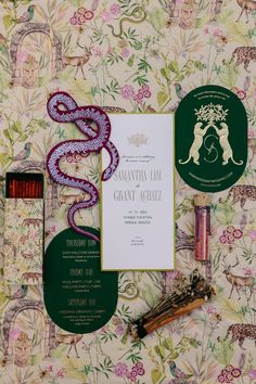 the wedding stationery is laid out neatly on top of the wall paper and other items