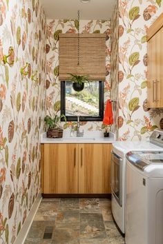 a washer and dryer in a small room with wall paper on the walls