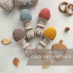 crochet patterns for wooden toys including mushrooms, leaves and balls of yarn on a white surface